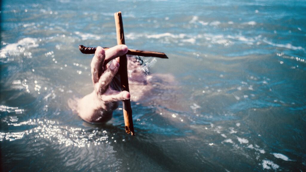 Main qui sort des eaux tenant la Croix du Christ.